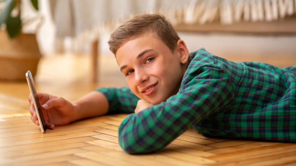 Niño con una tableta, sonriendo mientras intenta superar un sistema de verificación de edad