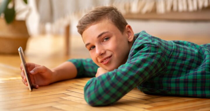 Niño con una tableta, sonriendo mientras intenta superar un sistema de verificación de edad