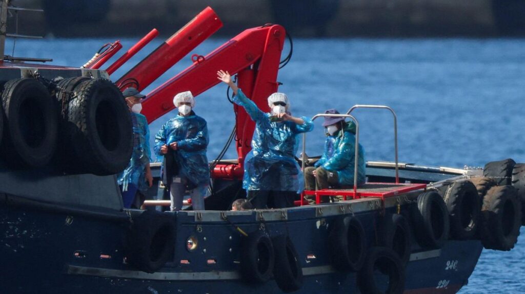 Pasajeros del crucero MV Hondius con mascarillas médicas blancas durante la evacuación