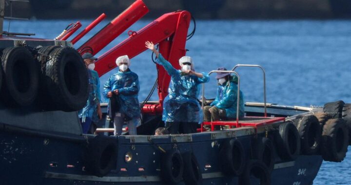 Pasajeros del crucero MV Hondius con mascarillas médicas blancas durante la evacuación