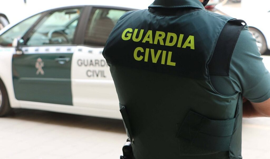 Imagen de una persona mayor en un aparcamiento de un supermercado con un fondo de policías trabajando