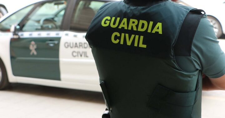 Imagen de una persona mayor en un aparcamiento de un supermercado con un fondo de policías trabajando