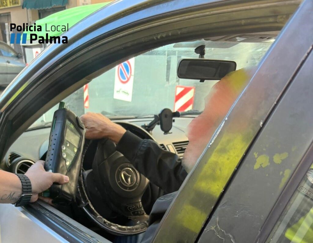 Imagen de un conductor siendo sometido a una prueba de alcoholemia por un agente de policía