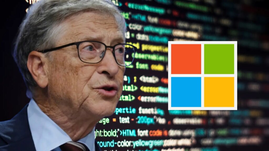 Bill Gates sonriendo mientras trabaja en su escritorio con una computadora de fondo