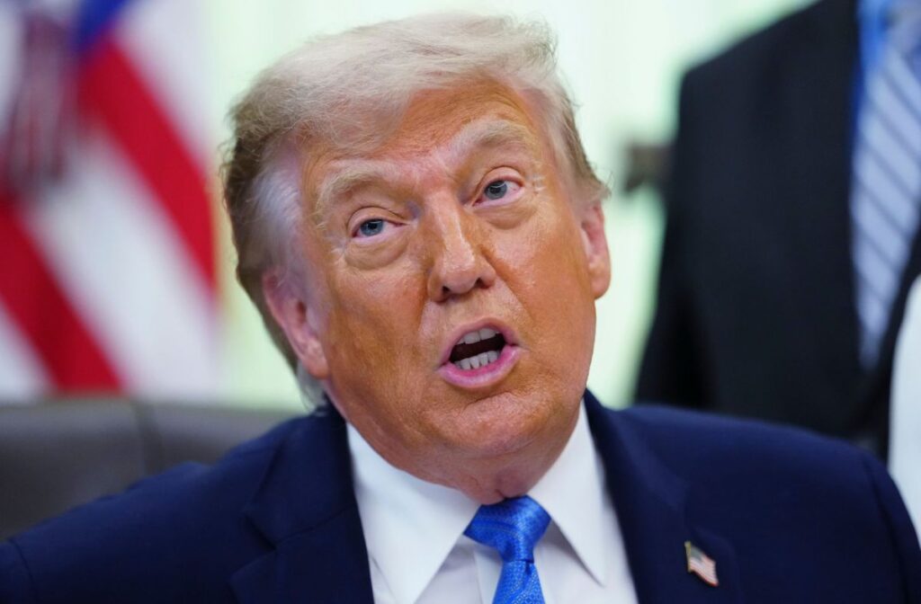 Donald Trump hablando en un podio con la bandera de Estados Unidos detrás, mientras anuncia la cancelación de ataques a Irán