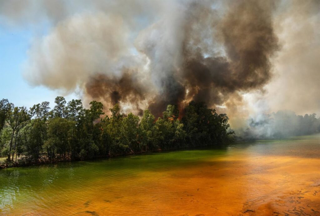 Imagen de un incendio forestal con llamas y humo intenso, 'UME' trabajando en labores de extinción.