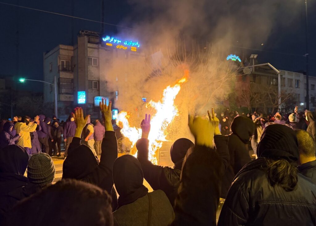 Manifestantes iraníes con carteles exigiendo justicia frente a cifras de muertos manipuladas por el régimen y la inacción global
